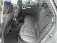 Vue intérieure arrière droite de l'Audi A6 Avant gris métal 2018, montrant les sièges en cuir et l'habitacle spacieux.