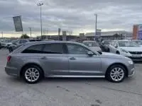 Profil droit d'une Audi A6 Avant 2.0 TDI S-Line gris métal de 2018, stationnée sur un parking extérieur.