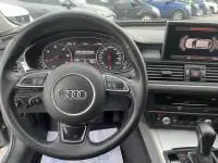 Vue intérieure de l'Audi A6 Avant 2.0 TDI 190 CV S-Line 2018, tableau de bord et volant multifonctions en noir.