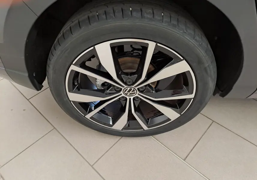Gros plan sur la jante alliage 18 pouces "Misano" bicolore noir et argent du Volkswagen Taigo gris cendré 2025.