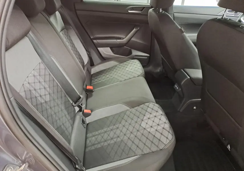 Intérieur arrière du Volkswagen Taigo gris cendré, vue côté gauche montrant les sièges tissu à motif géométrique.