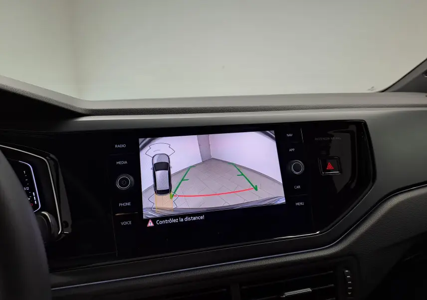 Vue intérieure du tableau de bord du Volkswagen Taigo 2025, écran affichant la caméra de recul avec guidage vert et rouge.