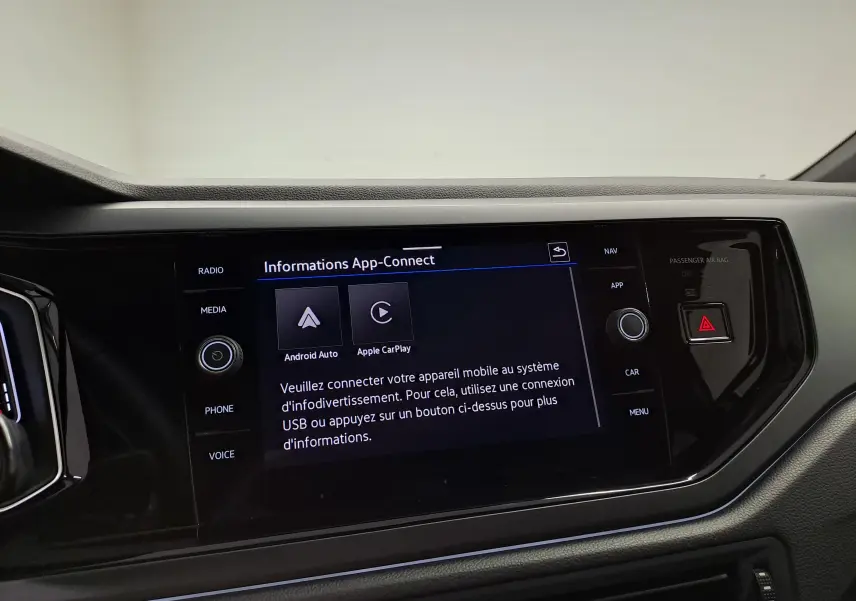 Vue de face du tableau de bord du Volkswagen Taigo gris cendré, avec écran tactile affichant les options Android Auto et Apple CarPlay.