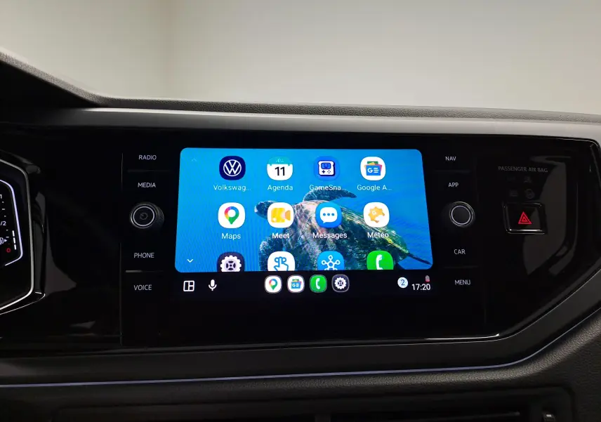 Écran tactile central du Volkswagen Taigo 2025 affichant des applications, entouré de commandes noires brillantes.