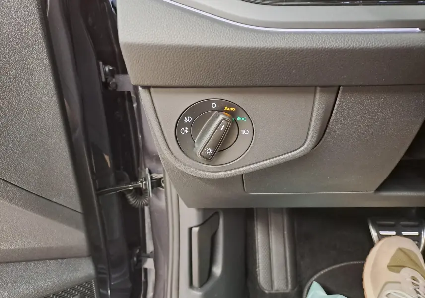 Gros plan sur le bouton de commande des phares dans l’habitacle du Volkswagen Taigo, côté conducteur.