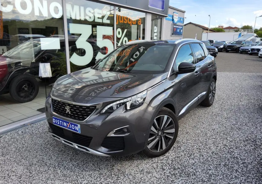 Peugeot 3008 gris métallisé en 3/4 avant droit avec jantes alliage et toit noir sur parking de concession.
