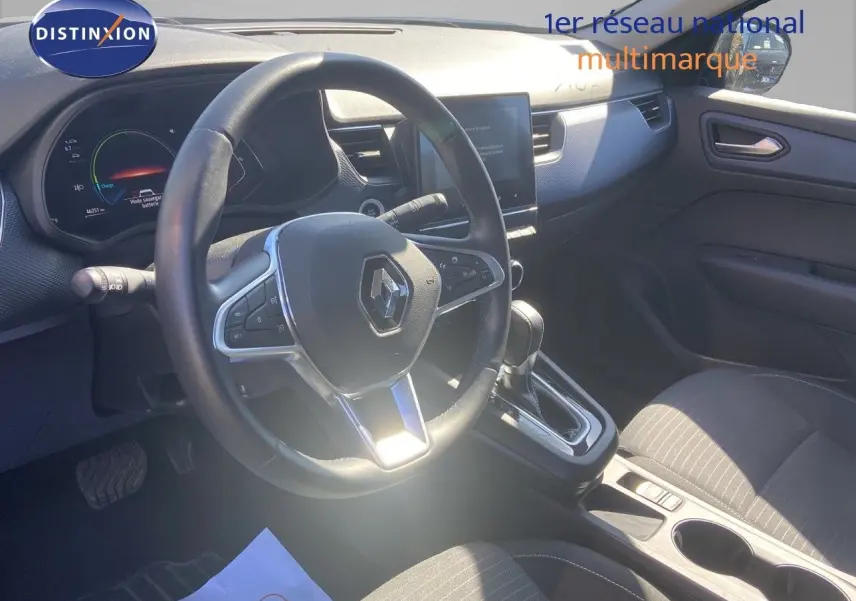 Vue intérieure côté conducteur du Renault Arkana hybride 2023, volant multifonction et console centrale avec boîte automatique.