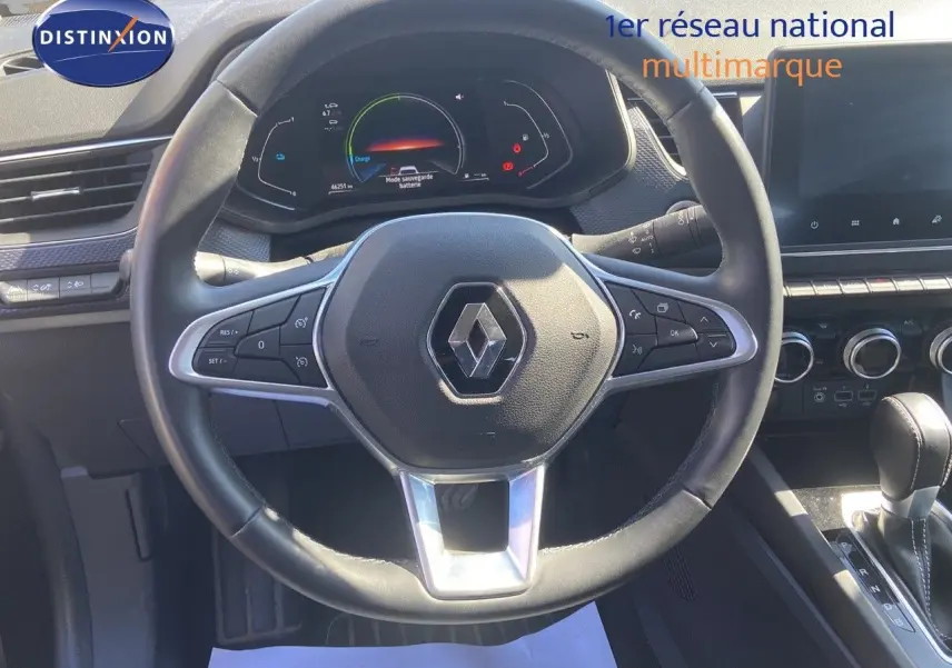 Vue rapprochée du volant noir du Renault Arkana 2023 avec tableau de bord numérique et commandes intégrées.