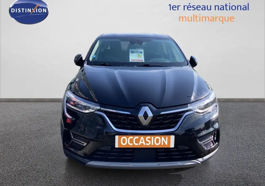 Vue avant d'une Renault Arkana noire métal 2023 avec calandre chromée et phares LED allumés.
