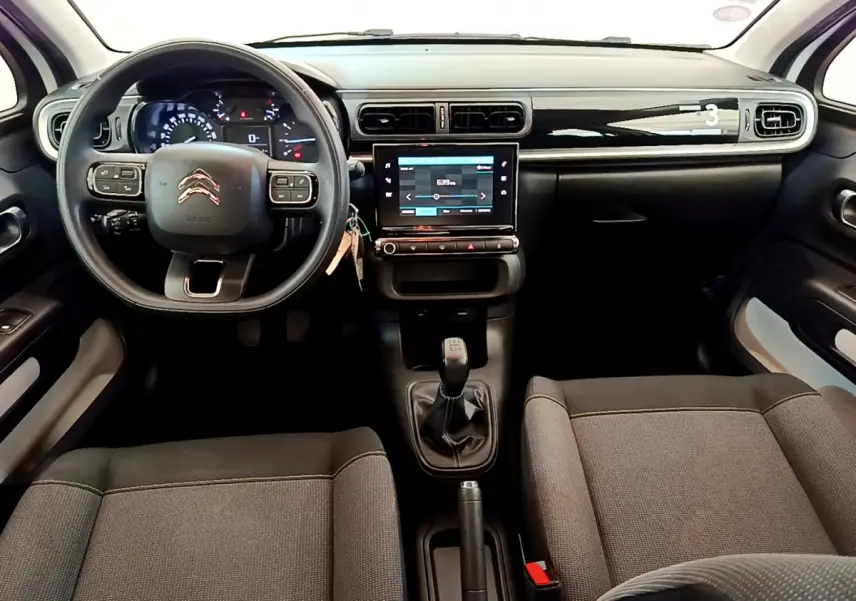 Intérieur de la Citroën C3 PureTech 82 blanc, vue de face sur le tableau de bord et la console centrale avec écran tactile.