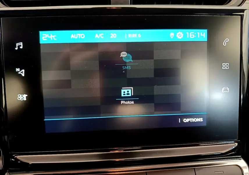 Écran tactile central du tableau de bord de la Citroën C3 blanche, affichant les options SMS et photos.