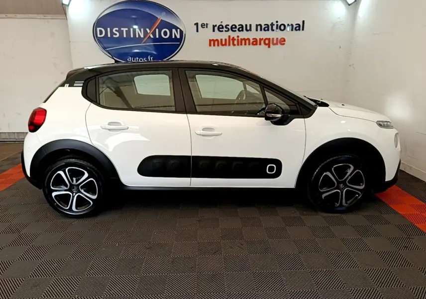 Profil côté gauche d'une Citroën C3 blanche 2019 avec toit noir et protections latérales noires distinctives.