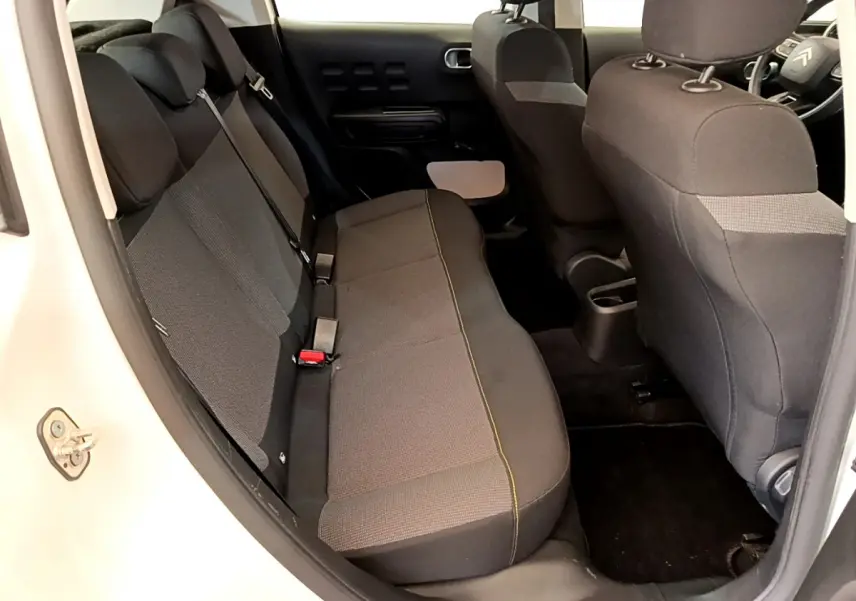 Vue intérieure côté gauche montrant la banquette arrière noire d'une Citroën C3 blanche de 2019.