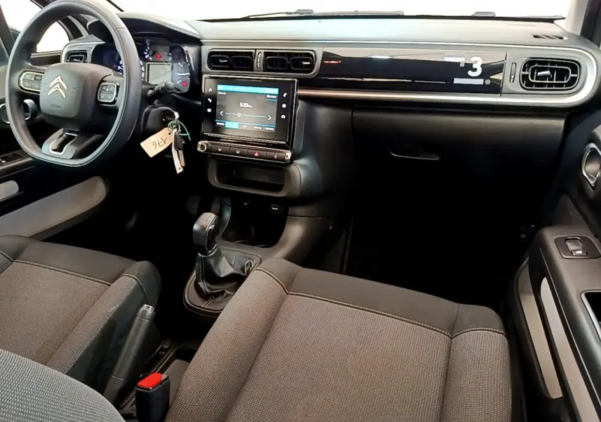 Intérieur avant de la Citroën C3 blanche 2019, vue côté conducteur, tableau de bord avec écran tactile et volant multifonctions.