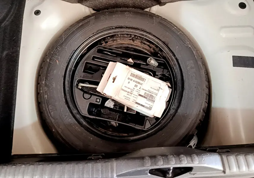 Roue de secours noire dans le coffre blanc d'une Citroën C3 PureTech 82 S&S BVM Graphic 2019.