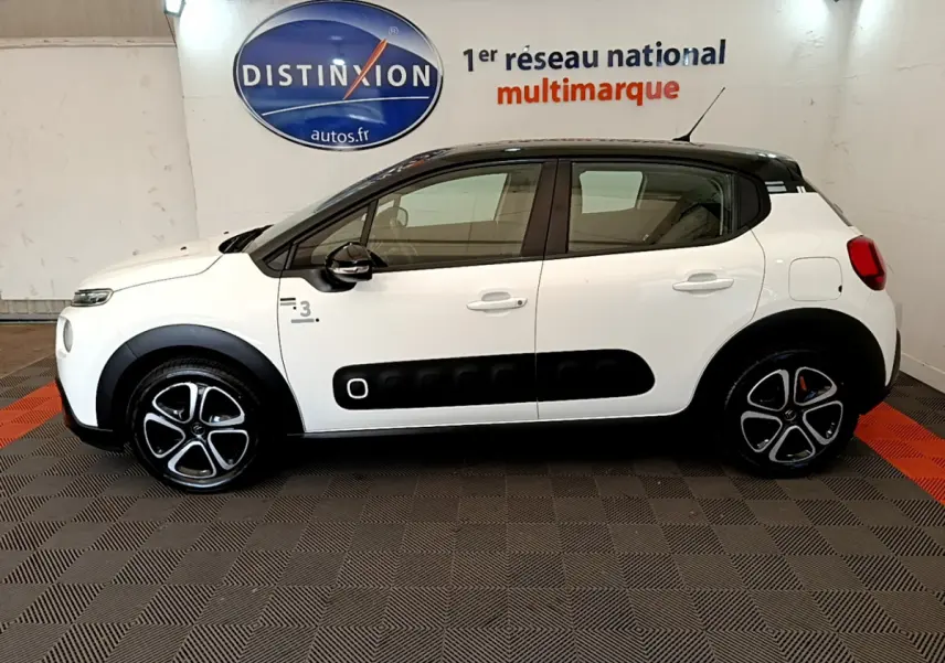 Profil côté gauche d'une Citroën C3 blanche 2019 avec toit noir et protections latérales noires distinctives.