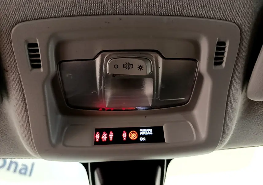 Vue en gros plan du plafonnier gris avec commandes d'éclairage et indicateurs d'airbags de la Citroën C3 blanche 2019.