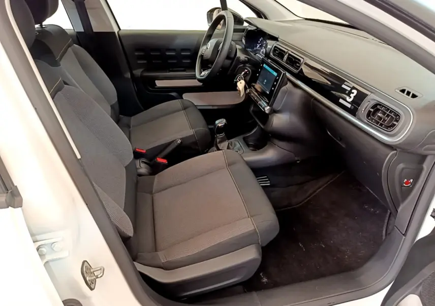 Intérieur de la Citroën C3 blanc, vue côté droit, sièges noirs et tableau de bord avec écran tactile central.