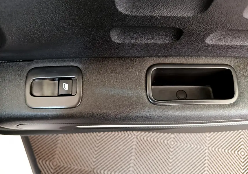 Gros plan sur la poignée intérieure et bouton de lève-vitre côté gauche de la porte d'une Citroën C3 blanche de 2019.