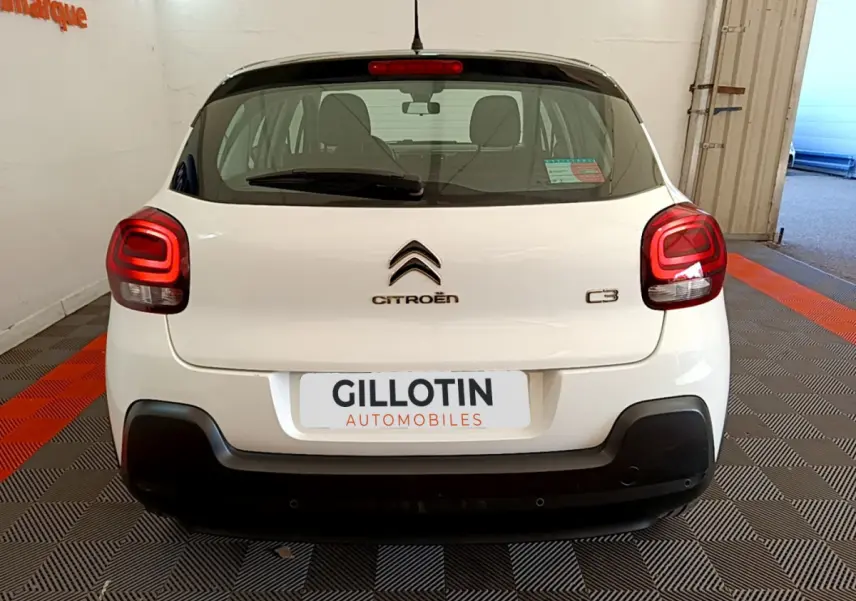 Vue arrière d'une Citroën C3 blanche de 2019 avec feux arrière LED et logo centré sur un fond noir.