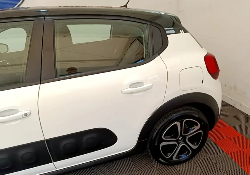 Vue latérale droite d'une Citroën C3 blanche avec protections noires et jantes au design distinctif.