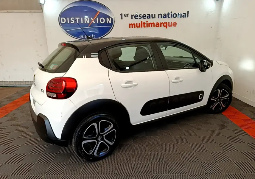 Citroën C3 PureTech 82 blanc vue 3/4 arrière côté droit avec toit noir et protections latérales noires.