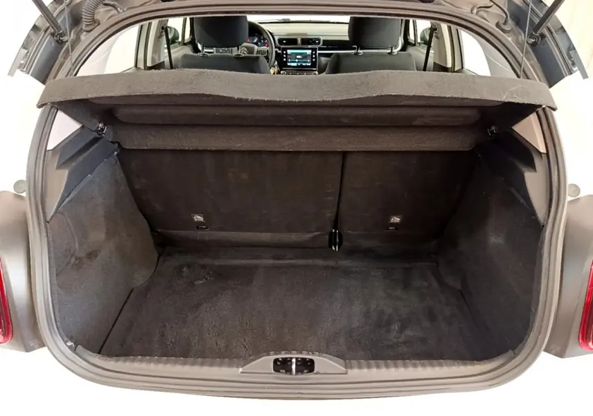 Coffre ouvert vu de l'arrière d'une Citroën C3 blanche, montrant l'espace de chargement et l'intérieur noir.