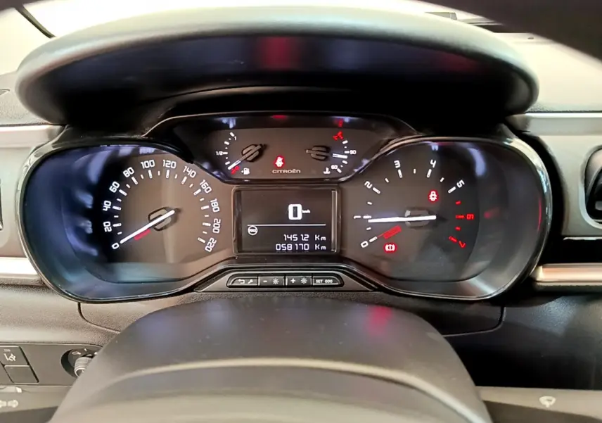 Tableau de bord de Citroën C3 PureTech 82 blanc, vue frontale centrée sur les compteurs numériques et analogiques.