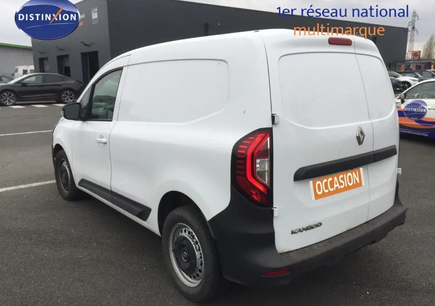 Vue 3/4 arrière droite d’un Renault Kangoo Extra blanc de 2023 avec feux arrière LED et marquage « occasion » sur la porte arrière.