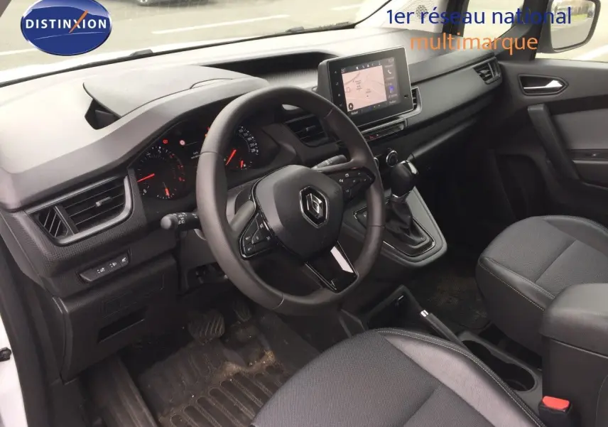 Vue intérieure côté conducteur du Renault Kangoo blanc 2023, avec tableau de bord moderne et écran tactile central.