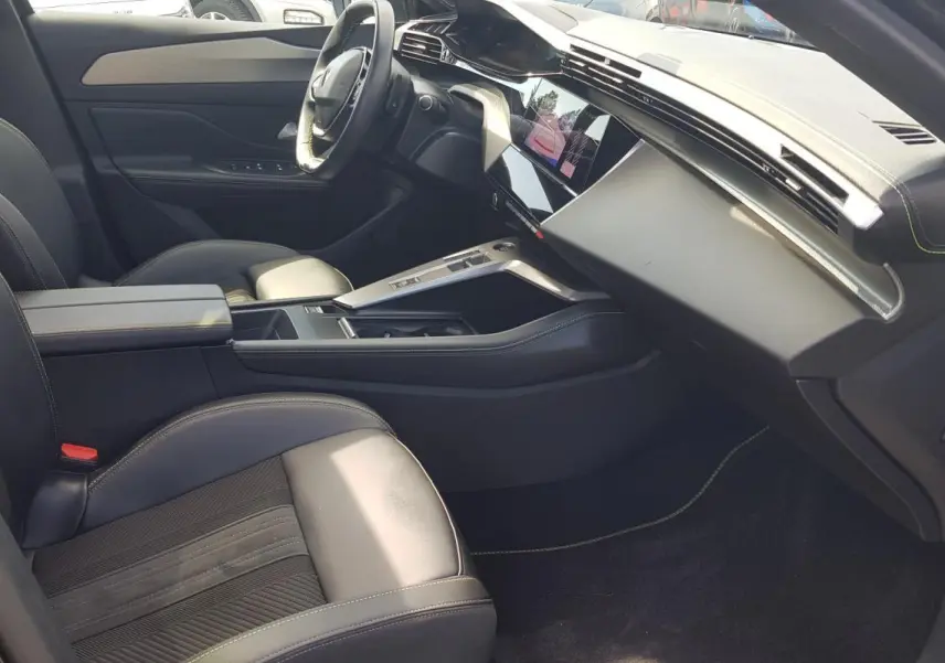 Intérieur noir du Peugeot 308 SW PHEV 225 GT vu côté passager, avec console centrale et volant cuir.