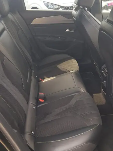 Vue intérieure côté droit des sièges arrière en cuir noir du Peugeot 308 SW PHEV 225 e-EAT8 GT 2023 avec finitions modernes.