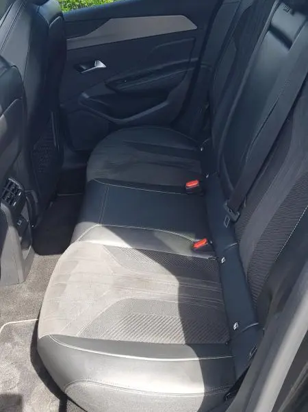 Vue intérieure côté droit des sièges arrière noirs en cuir et tissu du Peugeot 308 SW PHEV 225 e-EAT8 GT 2023.