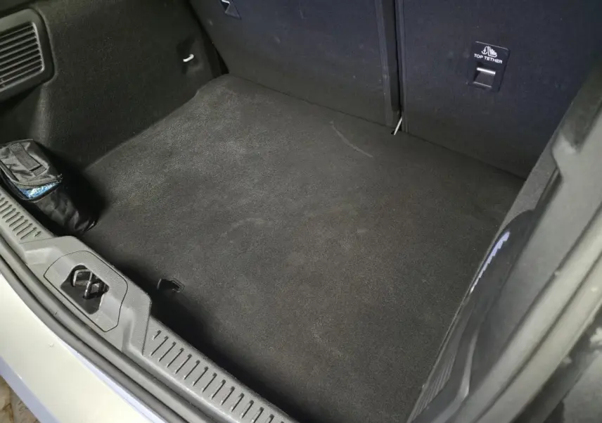 Vue plongeante sur le coffre spacieux et propre de la Ford Focus gris lunaire, avec tapis noir et fixation Top Tether visible.