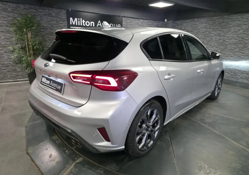 Vue 3/4 arrière droite d'une Ford Focus gris lunaire 2024 avec feux arrière LED et jantes alliage 17 pouces.