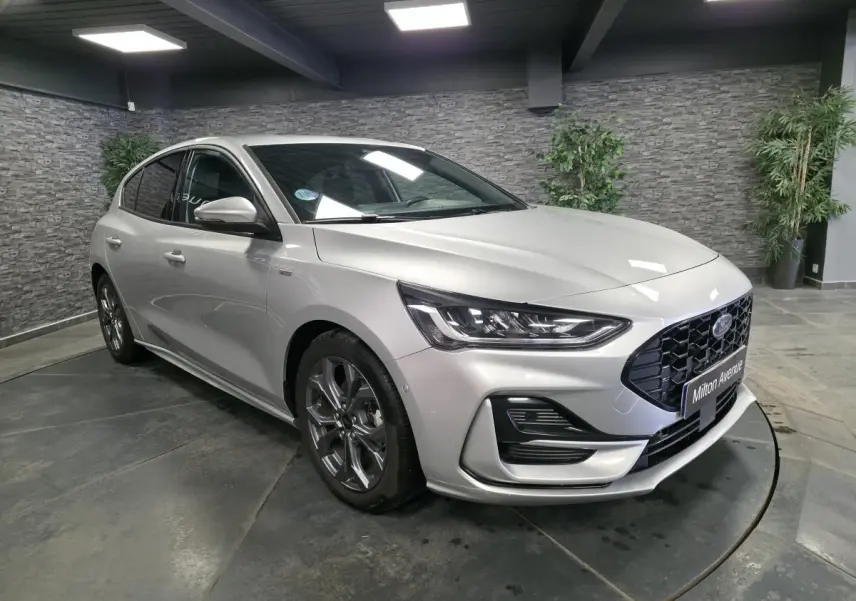 Vue 3/4 avant droite de la Ford Focus 2024 gris lunaire avec calandre noire et jantes alliage 17 pouces.