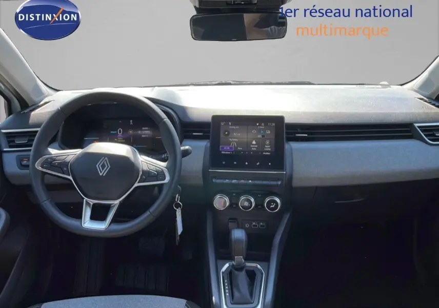 Intérieur de la Renault Clio hybride 2025 vu de face, tableau de bord moderne avec écran tactile et volant multifonction noir.