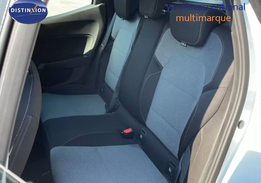 Vue intérieure côté arrière droit de la Renault Clio 2025 blanc glacier, montrant les sièges arrière en tissu bicolore gris et noir.