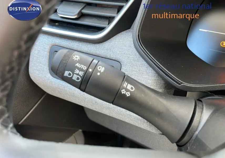 Gros plan sur la commande des feux et clignotants dans l’habitacle de la Renault Clio blanche Glacier 2025.
