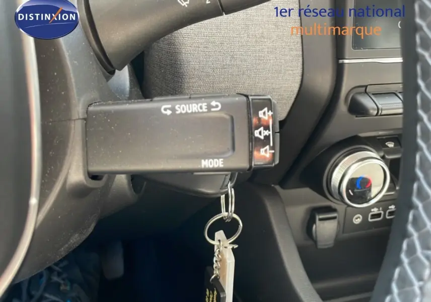 Détail intérieur du volant de la Renault Clio hybride 2025, montrant la commande multimédia et la clé suspendue.