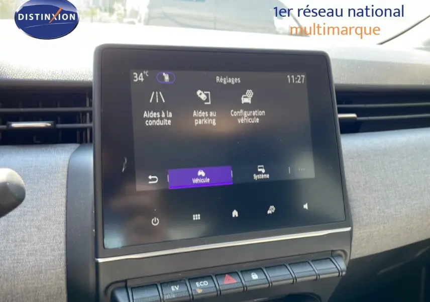 Écran tactile central de la Renault Clio blanc glacier 2025 montrant les réglages d’aides à la conduite et parking.