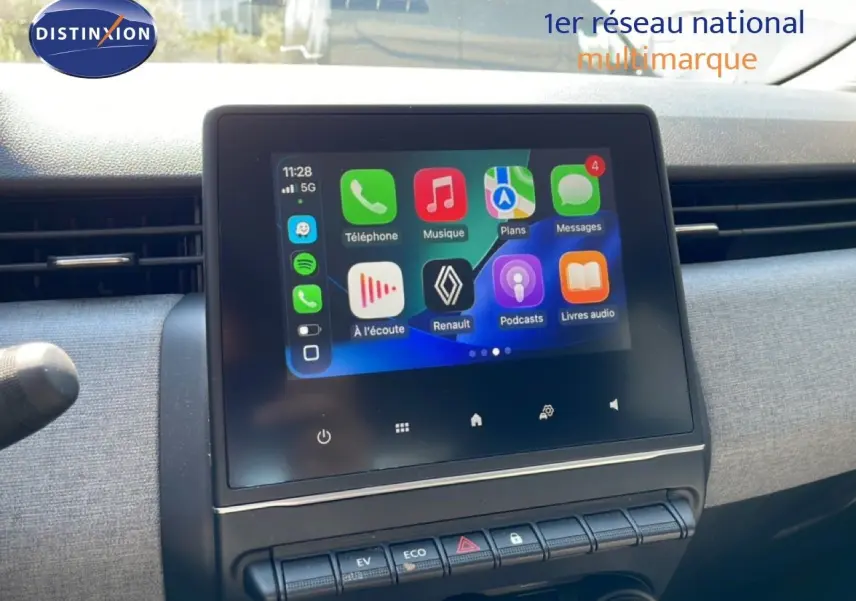 Vue rapprochée de l’écran tactile central de la Renault Clio hybride 2025 affichant l’interface Apple CarPlay colorée.