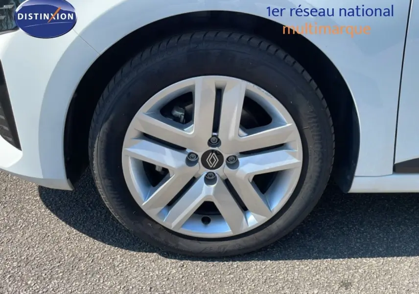 Gros plan sur la roue avant gauche blanche glacier d'une Renault Clio hybride 2025 avec jante alliage distinctive.