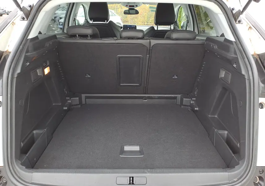Coffre ouvert d'un Peugeot 3008 blanc vu de l'arrière, montrant un espace de chargement propre et spacieux.