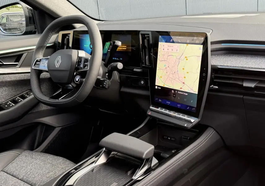 Intérieur du Renault Espace VI hybride, vue côté conducteur sur le tableau de bord et grand écran tactile vertical avec navigation.