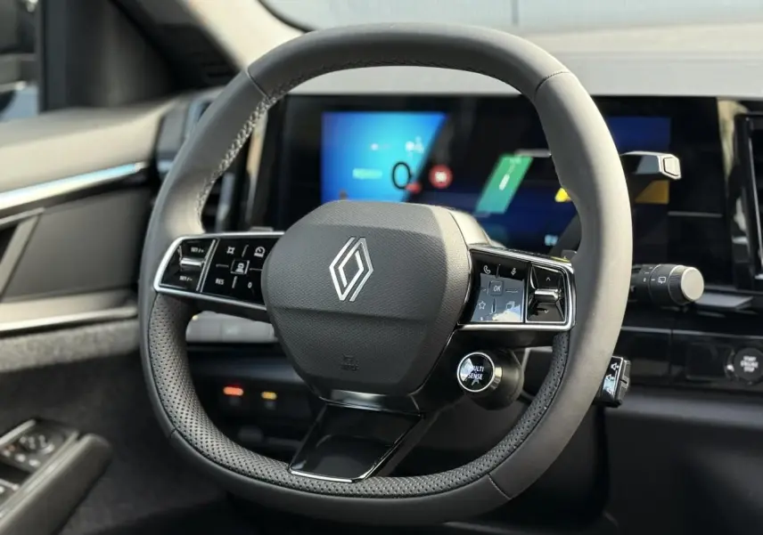 Volant textile grainé avec insert chrome de la Renault Espace VI 6 E-Tech, vue rapprochée du poste de conduite.