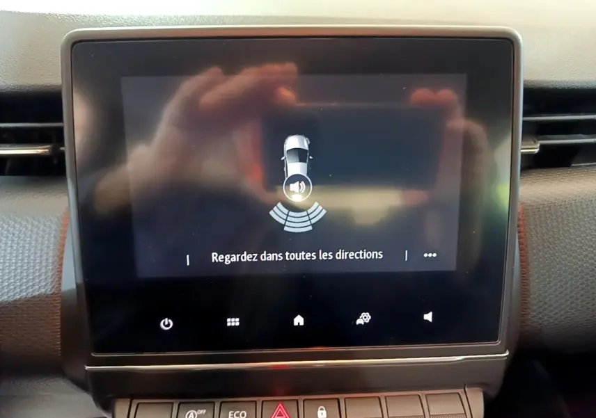 Écran tactile central de la Renault Clio Business blanc 2020 affichant l'alerte de surveillance des angles morts.