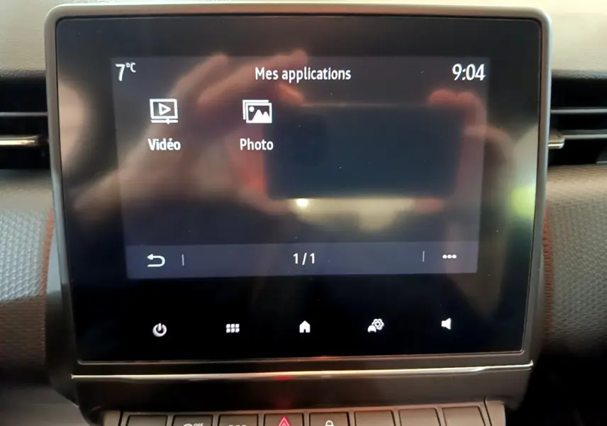 Écran tactile central affichant les applications vidéo et photo dans l'habitacle d'une Renault Clio Business blanche.