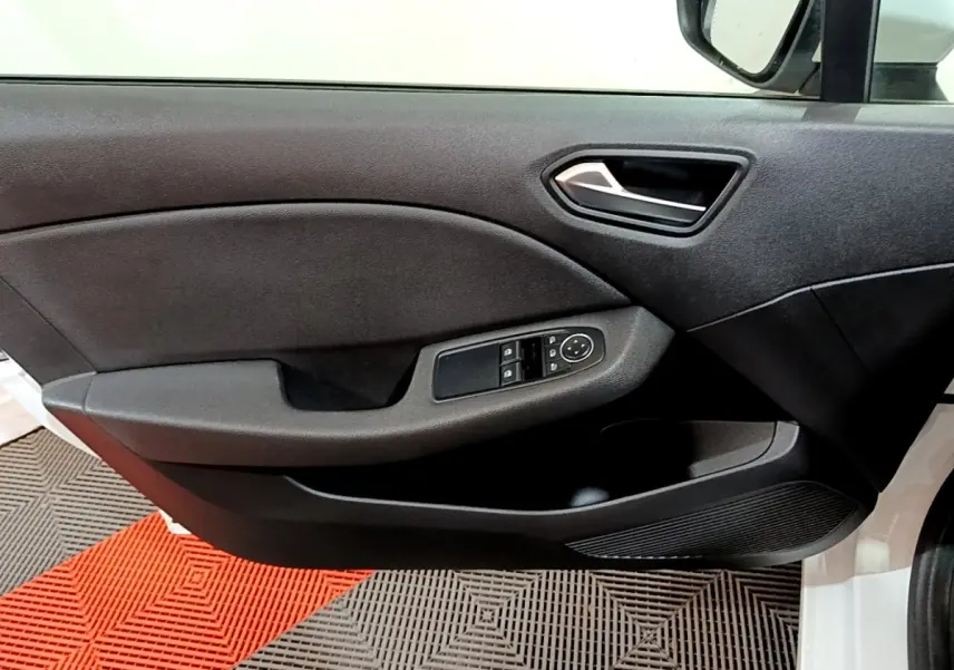 Intérieur côté conducteur de la Renault Clio Business blanc, montrant la portière avec commandes des vitres et rétroviseur.