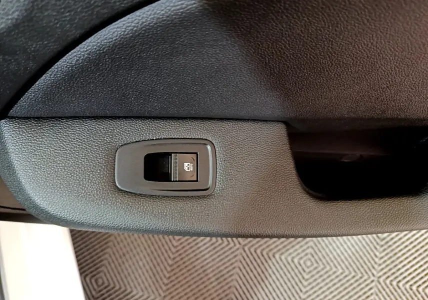 Bouton de verrouillage centralisé sur panneau de porte intérieure noire d'une Renault Clio Business Blue dCi 85 blanche.